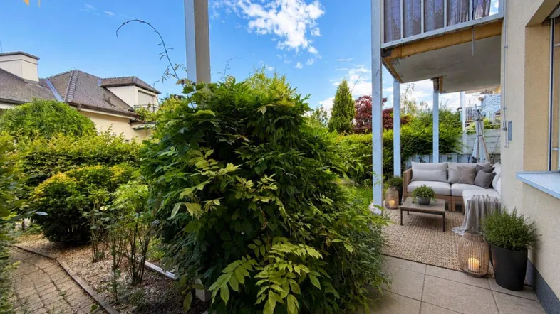 Gemütliche Terrasse mit Sitzgelegenheiten und üppiger Bepflanzung, ideal zum Entspannen im Freien.