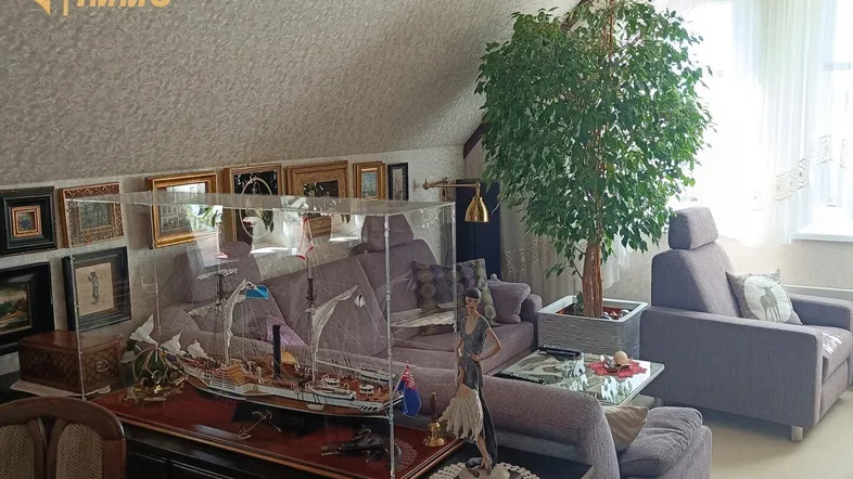 Geräumiges Wohnzimmer im Dachgeschoss mit gemütlichen Sofas und dekorativem Schiffsmodell.