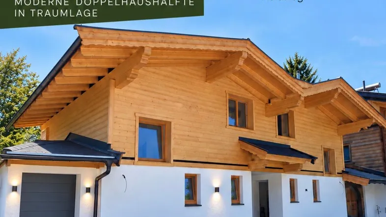 Moderne Doppelhaushälfte in Holzbauweise mit integrierter Garage und weißer Fassade.