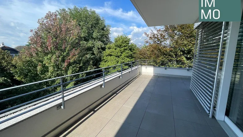 Geräumige Terrasse mit modernen Fliesen und Blick ins Grüne, ideal für Entspannung im Freien.