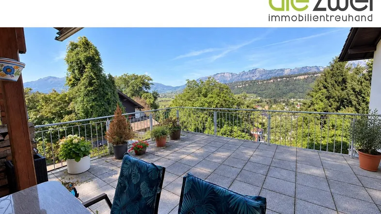 Große geflieste Terrasse mit Sitzgelegenheiten und weitem Blick auf die Berge und das Tal.
