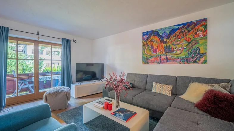 Helles Wohnzimmer mit großem Ecksofa, modernem Kunstwerk und Zugang zum Balkon.