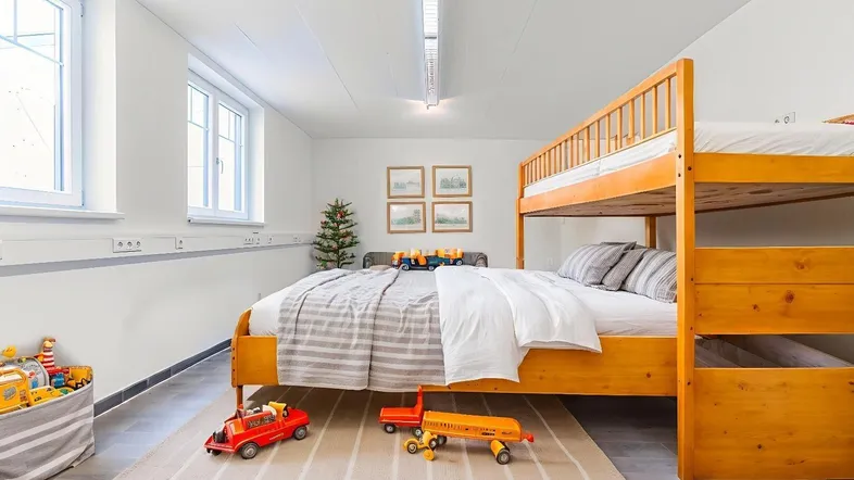 Geräumiges Kinderzimmer mit Etagenbett, Einzelbett und Fliesenboden, ideal für Geschwister.