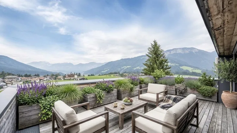 Geräumige Terrasse mit bequemen Gartenmöbeln, üppigen Pflanzen und einem atemberaubenden Blick auf die Berge.
