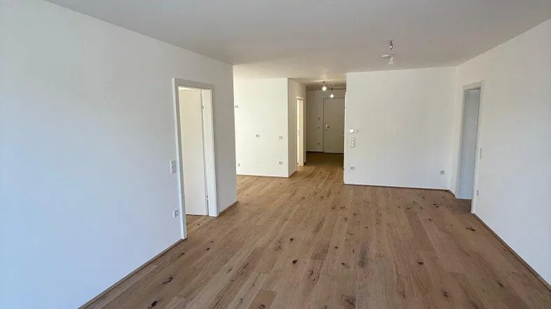 Geräumiges, helles Zimmer mit neuem Holzboden und weißen Wänden, bereit für die Einrichtung.