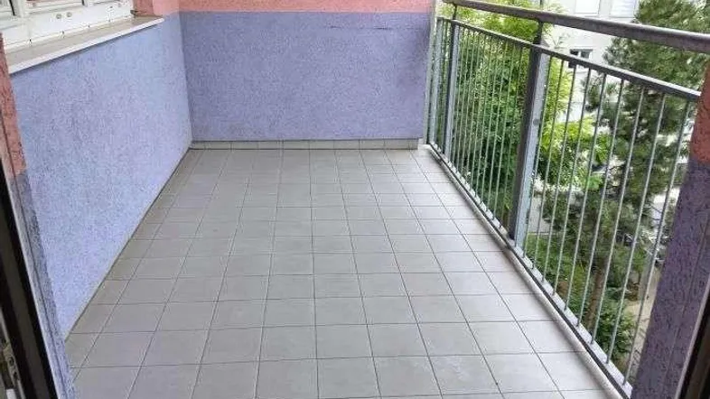 Gefliester Balkon mit Metallgeländer und Blick auf die Umgebung.
