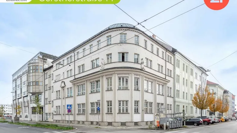 Historisches Eckgebäude mit klassischer Architektur und vielen Fenstern an einer Stadtstraße.