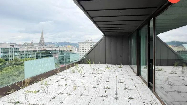 Große Dachterrasse mit Fliesenboden, Glasgeländer und weitem Blick über die Stadt.