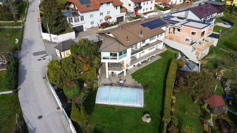 Luftaufnahme des Anwesens mit großem Garten, Pool und umliegender Wohnsiedlung in ländlicher Umgebung.