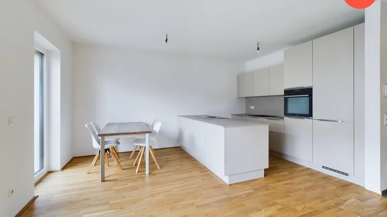 Moderne offene Küche mit Kücheninsel, Essbereich und Zugang zur Terrasse, ausgestattet mit hellem Parkettboden.