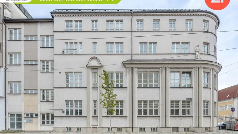 Ansicht der Gebäudefassade von der Straße aus mit vielen Fenstern und klassischer Architektur.