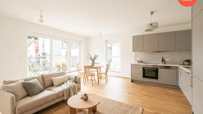 Heller, offener Wohn- und Essbereich mit integrierter Küche und Zugang zum Balkon.