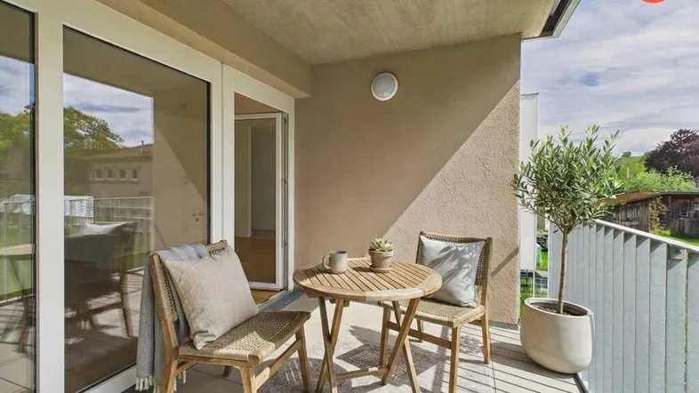 Gemütlicher Balkon mit Sitzgelegenheiten und Blick ins Grüne, ideal für entspannte Stunden im Freien.