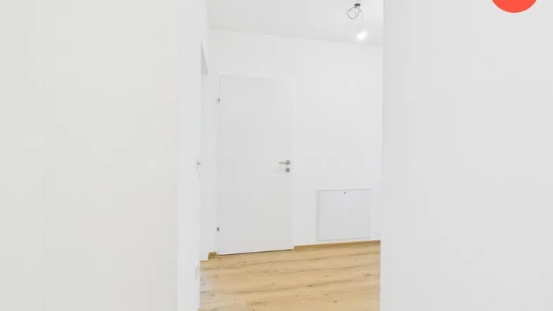 Heller Flur mit Laminatboden und weißen Wänden in einem Neubau.