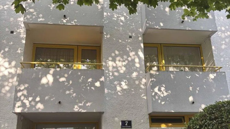 Fassade eines Mehrfamilienhauses mit Balkonen und Eingangsbereich.