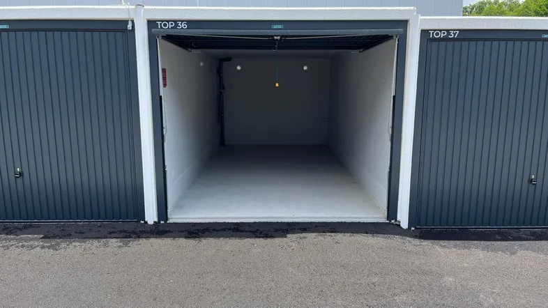 Leere, saubere Garagenbox mit Rolltor, bereit zur Nutzung als Lagerraum oder Stellplatz.