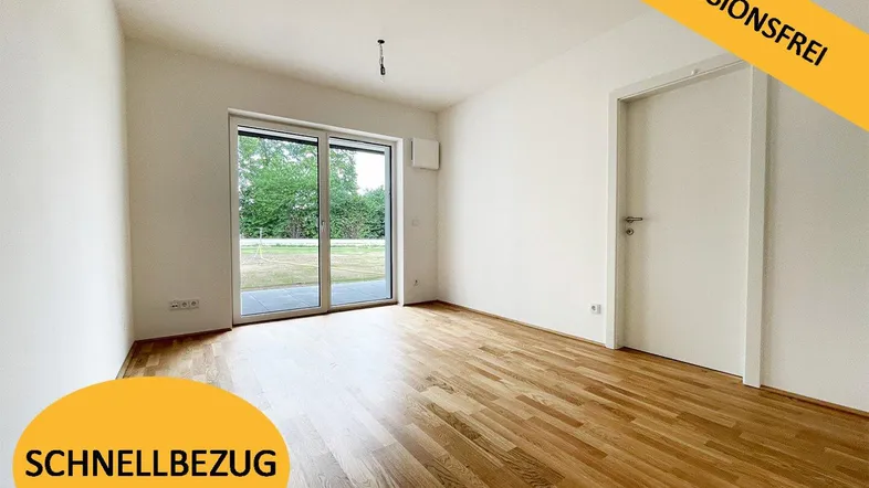 Helles Zimmer mit Parkettboden und Zugang zu einer Terrasse oder Gartenfläche.