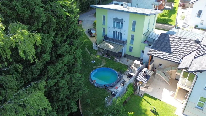 Luftaufnahme des Hauses mit Garten, Pool und umliegender grüner Landschaft.