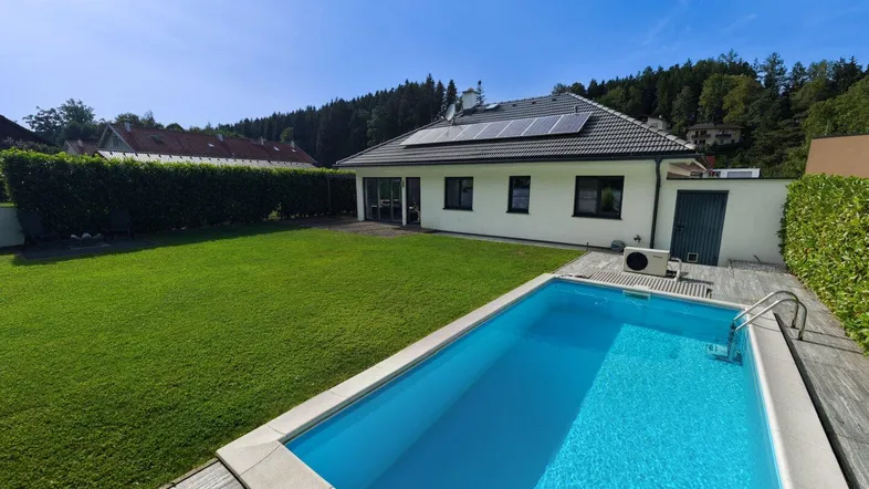 Modernes Einfamilienhaus mit großem Garten, privatem Pool und Photovoltaikanlage auf dem Dach.