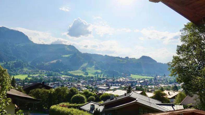 Panoramablick auf die Stadt und die umliegenden Berge von einem sonnigen Aussichtspunkt.