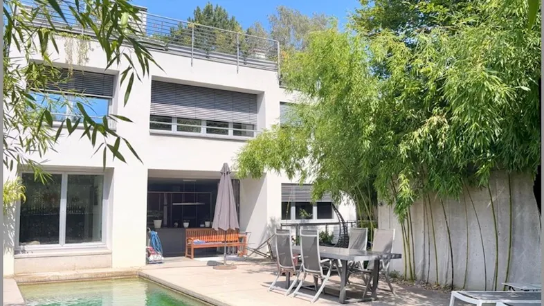 Moderne Villa mit privatem Pool, sonniger Terrasse und üppiger Bambusbepflanzung.