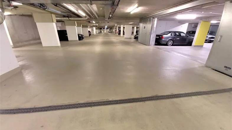 Geräumige Tiefgarage mit zahlreichen Stellplätzen und moderner Beleuchtung, bietet sichere Parkmöglichkeiten für Bewohner.