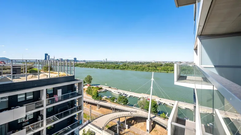 Panoramablick auf die Donau, eine Marina und die Skyline der Stadt von einem modernen Gebäude aus.