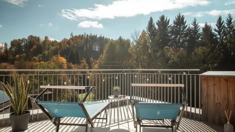 Sonniger Balkon mit bequemen Sitzgelegenheiten und weitem Blick auf die bewaldete Landschaft.