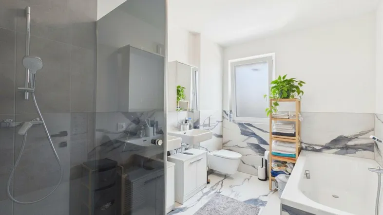 Modernes Badezimmer mit begehbarer Dusche, Badewanne und eleganten Marmorfliesen.