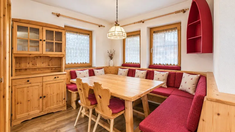 Gemütlicher Essbereich im Landhausstil mit Holztisch, Eckbank und traditionellen Möbeln.