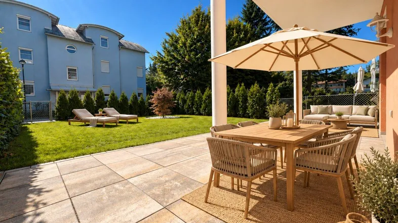 Geräumige Terrasse mit modernen Gartenmöbeln, Sonnenschirm und Blick auf den gepflegten Gartenbereich.