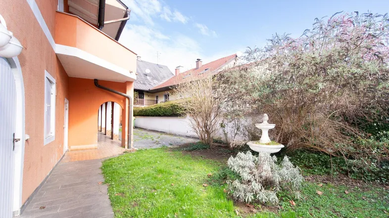 Kleiner Gartenbereich mit Zierbrunnen und Zugang zum Gebäude.