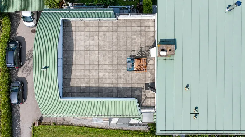 Luftaufnahme des Hauses mit großer Dachterrasse und angrenzendem Gartenbereich.