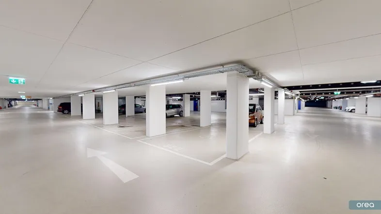 Helle und geräumige Tiefgarage mit vielen Parkplätzen, guter Beleuchtung und klaren Markierungen.