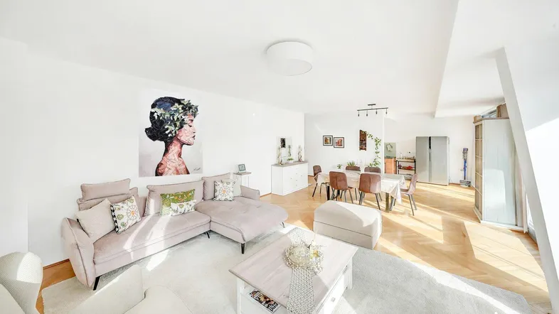 Helles und geräumiges Wohn-Esszimmer mit modernem Sofa, Esstisch und Parkettboden.