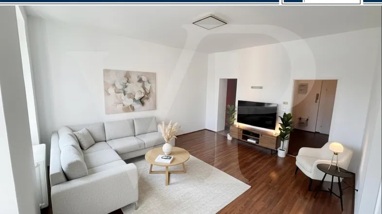 Helles Wohnzimmer mit modernem Sofa, Holzboden und einem Teppich, ideal für entspannte Abende.