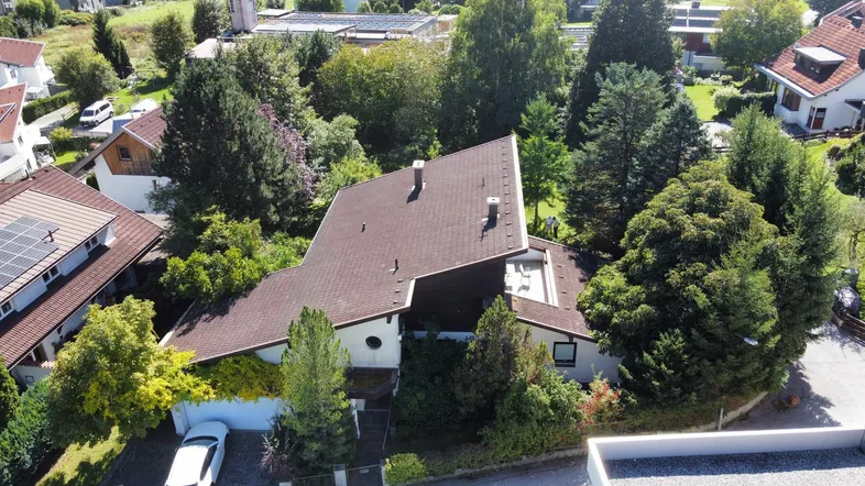 Luftaufnahme des Hauses mit großem Grundstück, umgeben von weiteren Wohnhäusern und viel Grün.