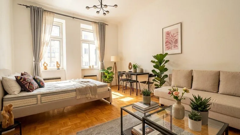 Helles Wohn- und Schlafzimmer mit Parkettboden, großen Fenstern und moderner Einrichtung.
