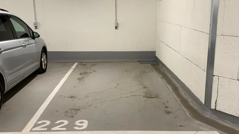 Einzelner Stellplatz Nummer 229 in einer sauberen Tiefgarage mit Betonboden und Deckenbeleuchtung.