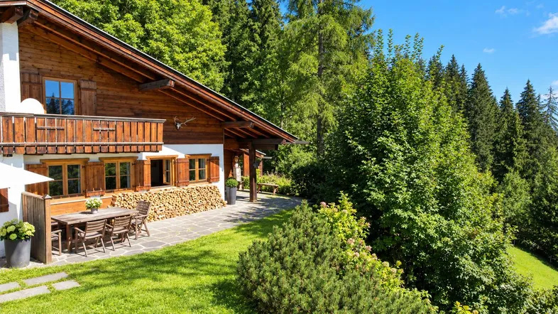 Traditionelles Holzchalet mit großer Terrasse und Garten in sonniger Hanglage.