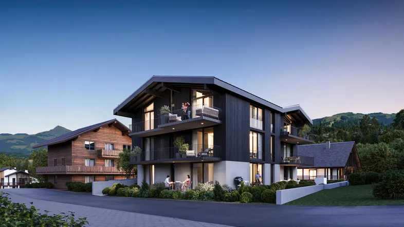 Moderne Architektur mit dunkler Holzfassade, Balkonen und Bergblick in alpiner Umgebung.