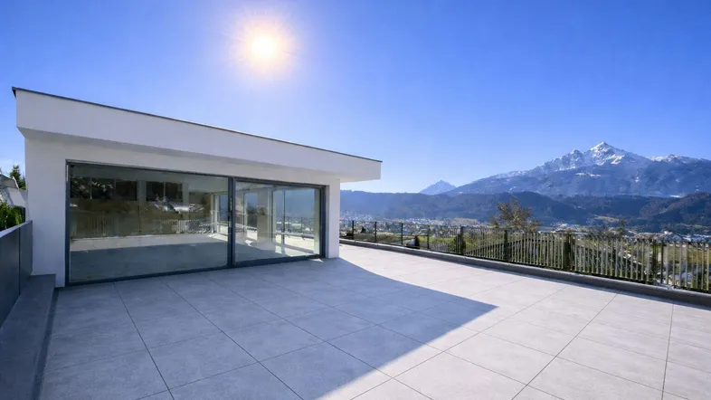Große, sonnige Dachterrasse mit weitem Bergblick und moderner Architektur.
