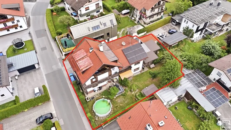 Luftaufnahme des Anwesens mit umliegenden Häusern und Gartenbereich, umrandet von einer roten Linie.