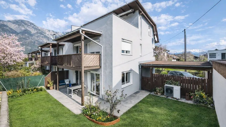 Modernes Reihenhaus mit gepflegtem Garten, Terrasse und Bergblick in sonniger Lage.