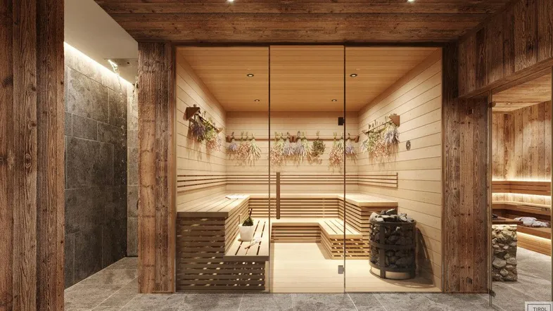 Geräumige Sauna mit Holzverkleidung, Steinofen und entspannender Atmosphäre, ideal für Wellness.