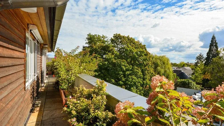 Geräumige Terrasse mit üppiger Bepflanzung und weitem Blick in die grüne Umgebung.