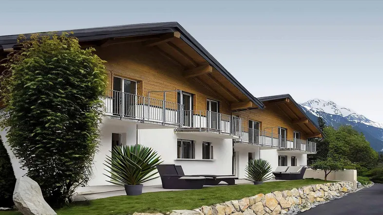 Modernes Gebäude mit Holzfassade, Balkonen und Bergblick in alpiner Umgebung.