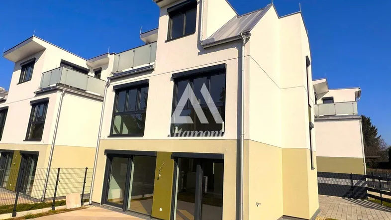 Moderne Reihenhäuser mit heller Fassade, großen Fenstern und privater Terrasse im Erdgeschoss.