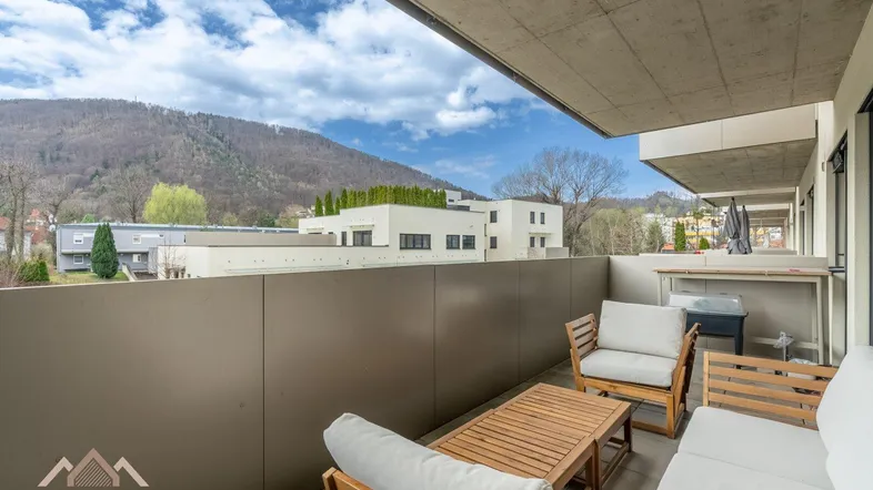 Balkon mit Sitzgelegenheiten und weitem Blick auf die bewaldeten Hügel und die Umgebung.
