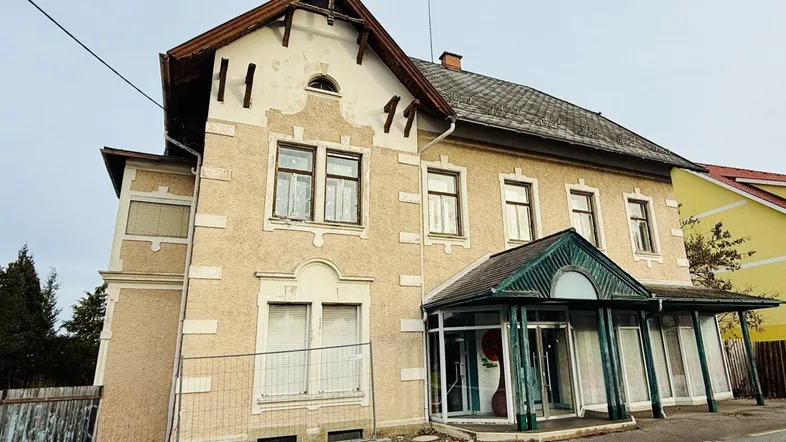 Vorderansicht eines älteren Gebäudes mit markantem Eingangsbereich und traditioneller Architektur.